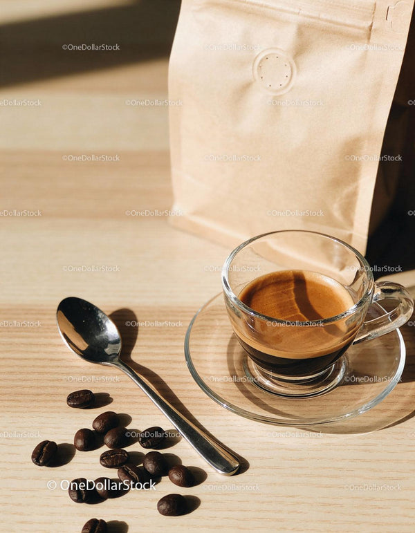 Freshly brewed espresso with coffee beans and spoon