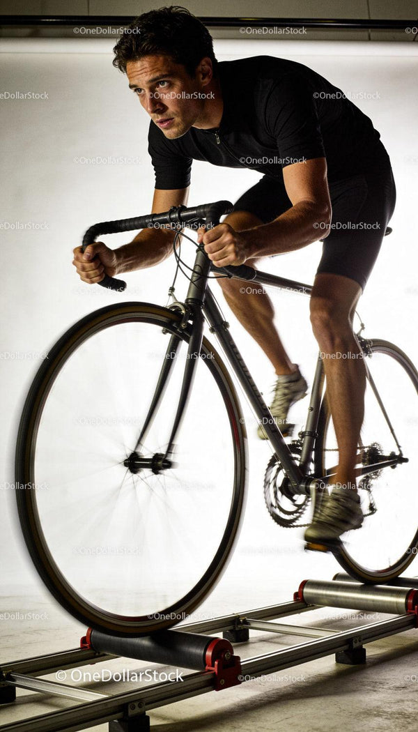 Focused cyclist training intensely on indoor roller trainer