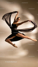 Graceful ballet dancer leaping with flowing fabric