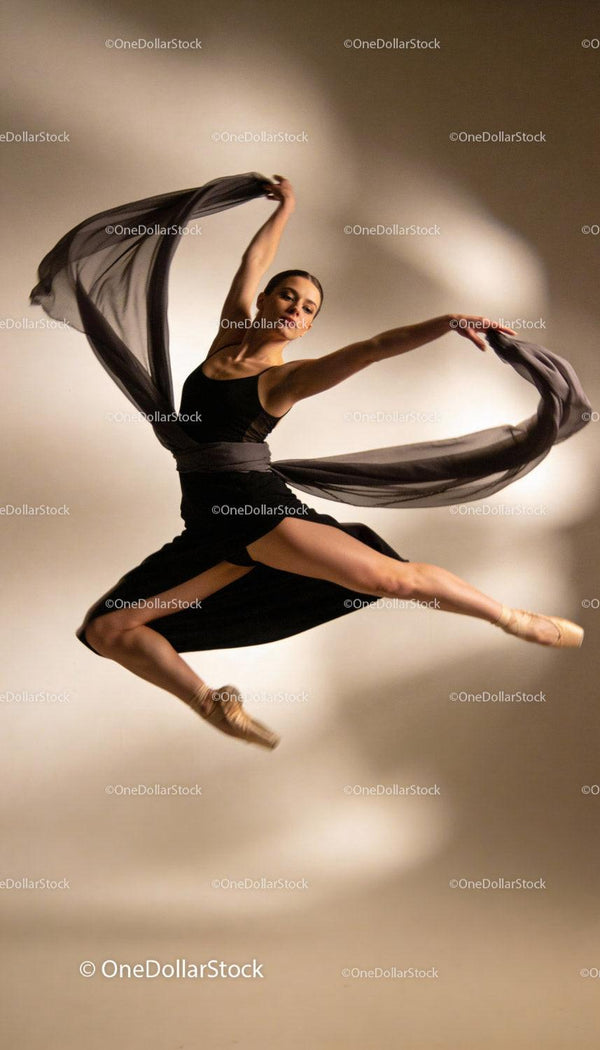 Graceful ballet dancer leaping with flowing fabric