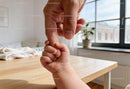 Baby Holding Parent Finger in Bright Cozy Home