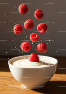 Fresh raspberries falling into creamy yogurt bowl
