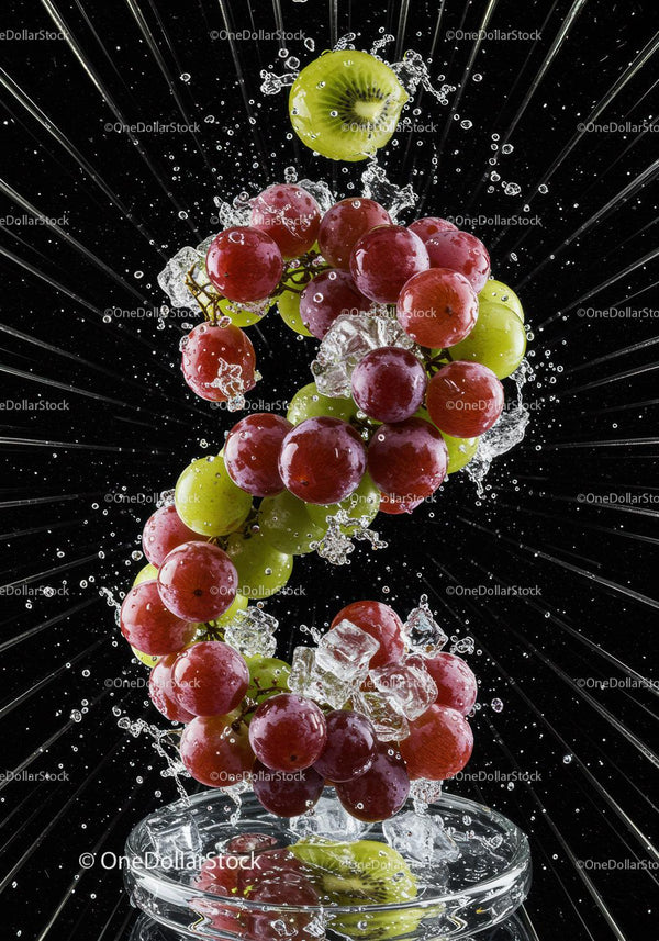 Fresh grapes and kiwi splashing into water with ice