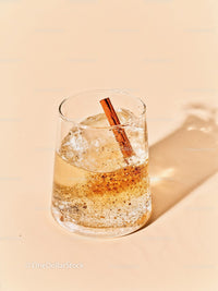 Refreshing fizz cocktail with cinnamon stick on beige