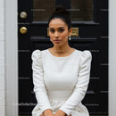 Elegant young woman in white dress posing outdoors