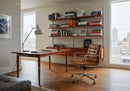 Modern office space with wooden desk and leather chair