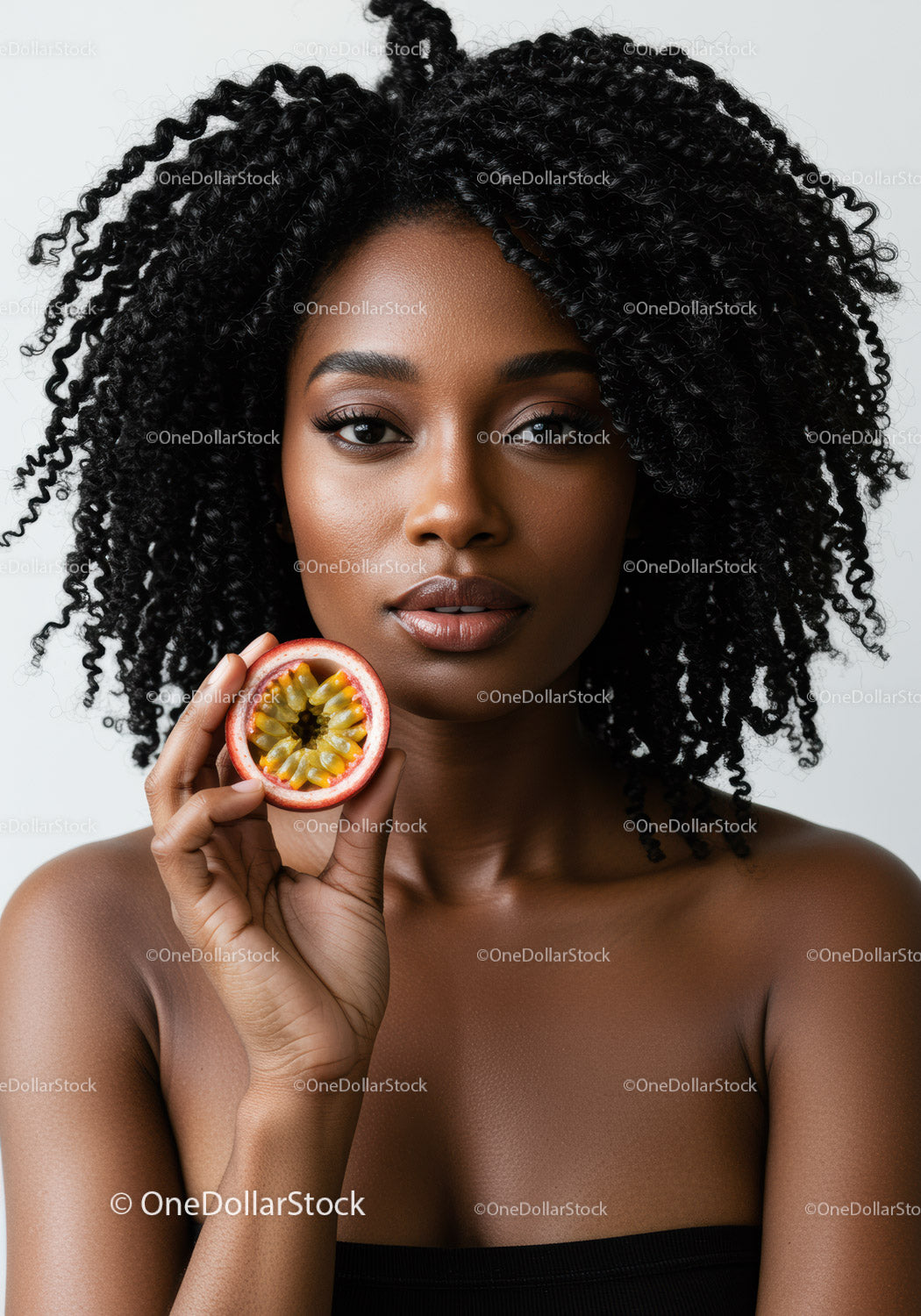 Elegant Portrait of a Black Woman with Curly Hair Holding Passion Fruit