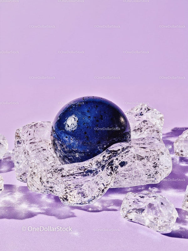 Blue spherical object resting on clear ice pieces