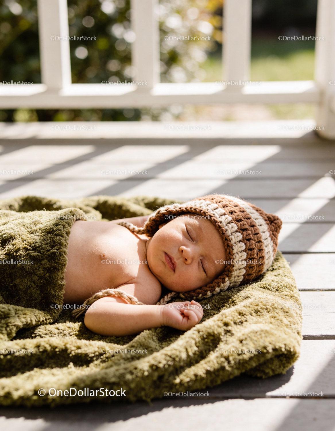 Newborn baby peacefully sleeping wrapped in green blanket