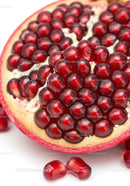 Close up of ripe pomegranate seeds on white background