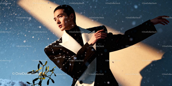 Stylish man posing gracefully amid falling snowflakes