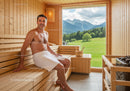 Man Relaxing in Wooden Sauna Room with Mountain View
