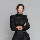 Elegant Woman in Black Dress Standing Confidently Against Grey Background