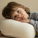 Thoughtful child resting head on cushion indoors