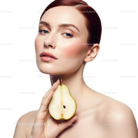 Elegant Portrait of a Woman Holding a Green Pear with Flawless Skin