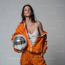 Stylish Woman in Metallic Outfit Holding Disco Ball for Modern Fashion