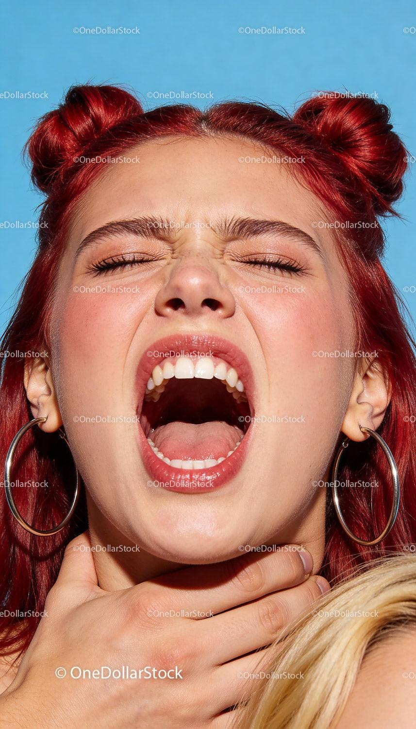 Young woman expressing intense emotion with red hair