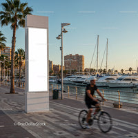 Cyclist Passing by Marina with Blank Vertical Billboard