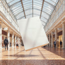 Blank white flyer floating in bright shopping mall corridor