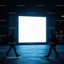 Silhouettes Walking Past Bright Digital Billboard at Night