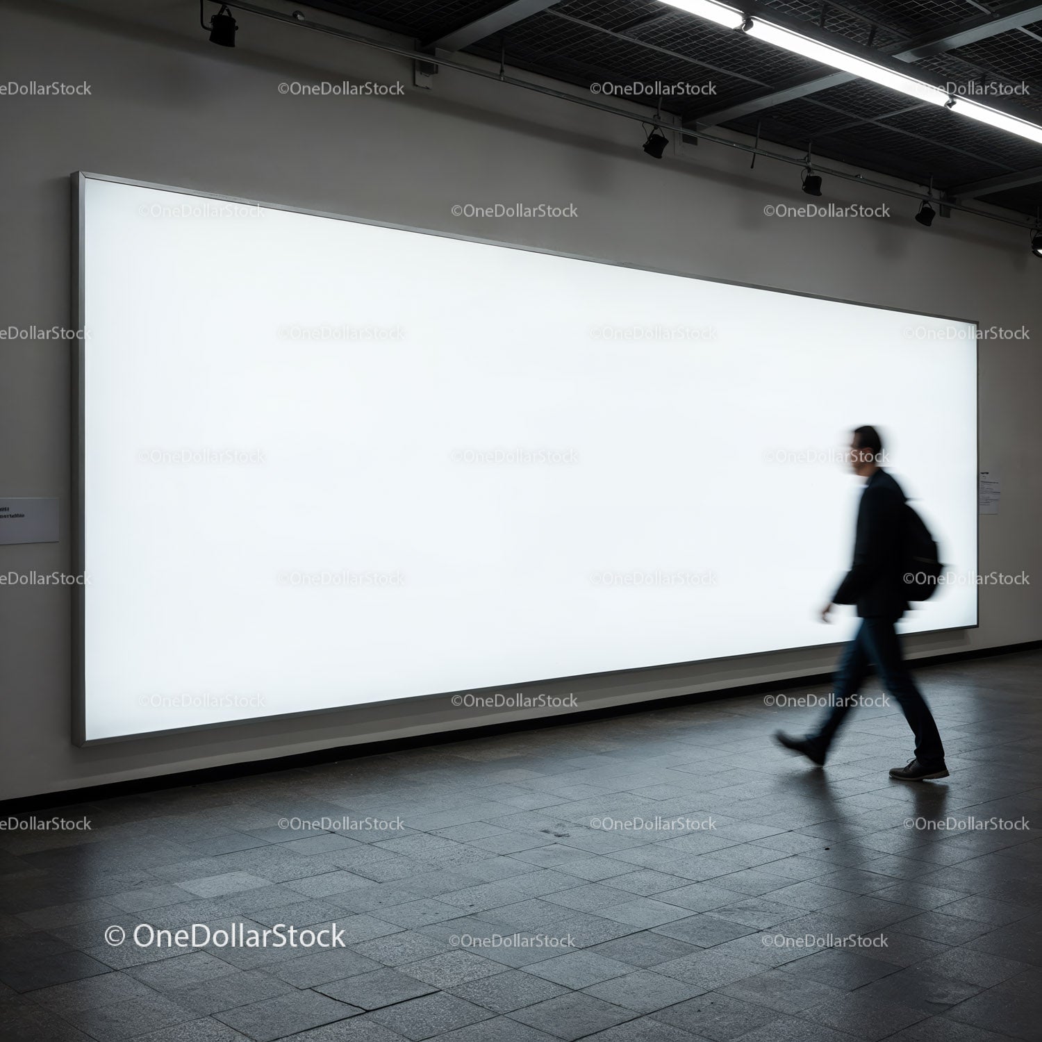 Businessman walking past large white illuminated billboard