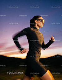 Focused woman running outdoors during vibrant sunset