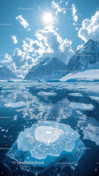 Majestic Snow-Capped Mountains and Floating Icebergs Under Bright Sun