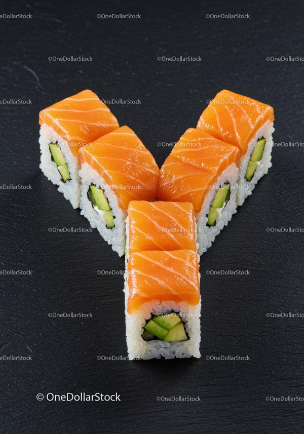 Fresh salmon sushi rolls with cucumber on black slate