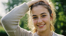 Young Woman Smiling Outdoors in Sunlight with Natural Beauty