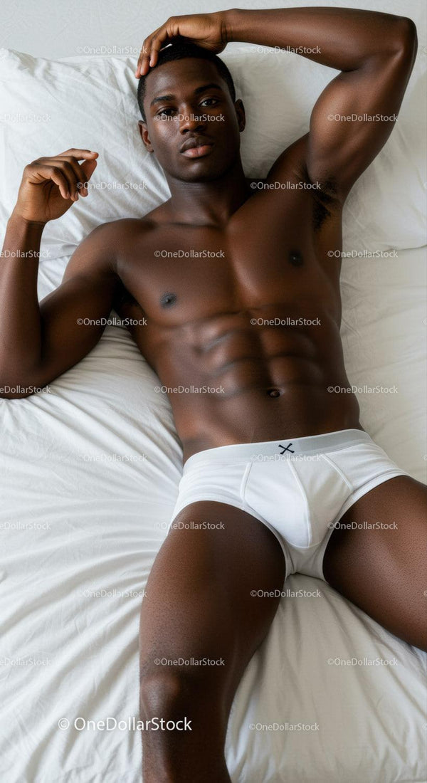 Relaxed young man reclining on white bed in underwear