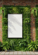 Blank board surrounded by lush green plants on brick wall