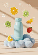 Blue Bottle on Soft Cloud with Floating Fruit Slices
