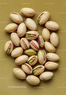 Shelled and Unshelled Pistachios on Olive Green Surface