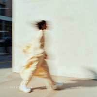 Stylish Woman in Motion Wearing Elegant Beige Outfit