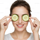 Woman holding cucumber slices over eyes smiling joyful healthy lifestyle