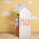 Smiling child peeking from giant milk carton box