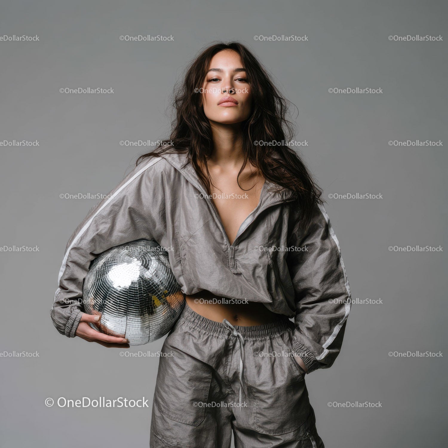 Stylish Woman in Metallic Outfit Holding Disco Ball for Modern Fashion