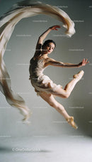 Graceful ballet dancer leaping with flowing fabric