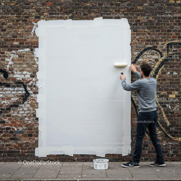 Man Covering Graffiti with White Paint on Brick Wall JPG Mockup Image