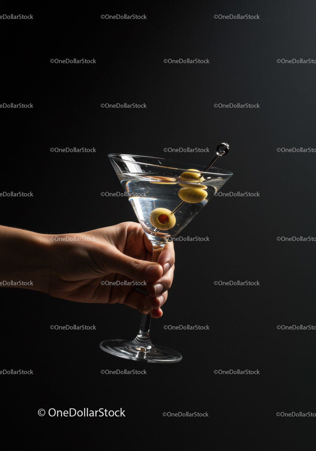 Klasyczny Martini z zielonymi oliwkami w dłoni