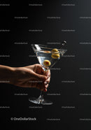 Hand Holding Classic Martini With Green Olives