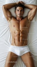Fit young man relaxing on bed wearing white underwear