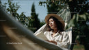 Young Woman Relaxing in Garden Hammock on Sunny Day