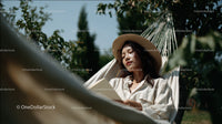 Young Woman Relaxing in Garden Hammock on Sunny Day
