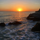 Beautiful Sunset Over Rocky Coastline with Calm Ocean Waves