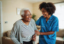 Caring Nurse Supporting Elderly Woman During Home Visit