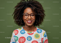 Joyful Woman with Curly Hair and Colorful Shirt Against Green Background
