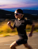 Woman Running Fast Along Mountain Road at Sunset