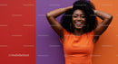 Vibrant Lifestyle Portrait of Smiling Woman with Curly Hair in Orange Dress