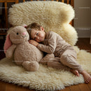Toddler resting peacefully with plush bunny toy